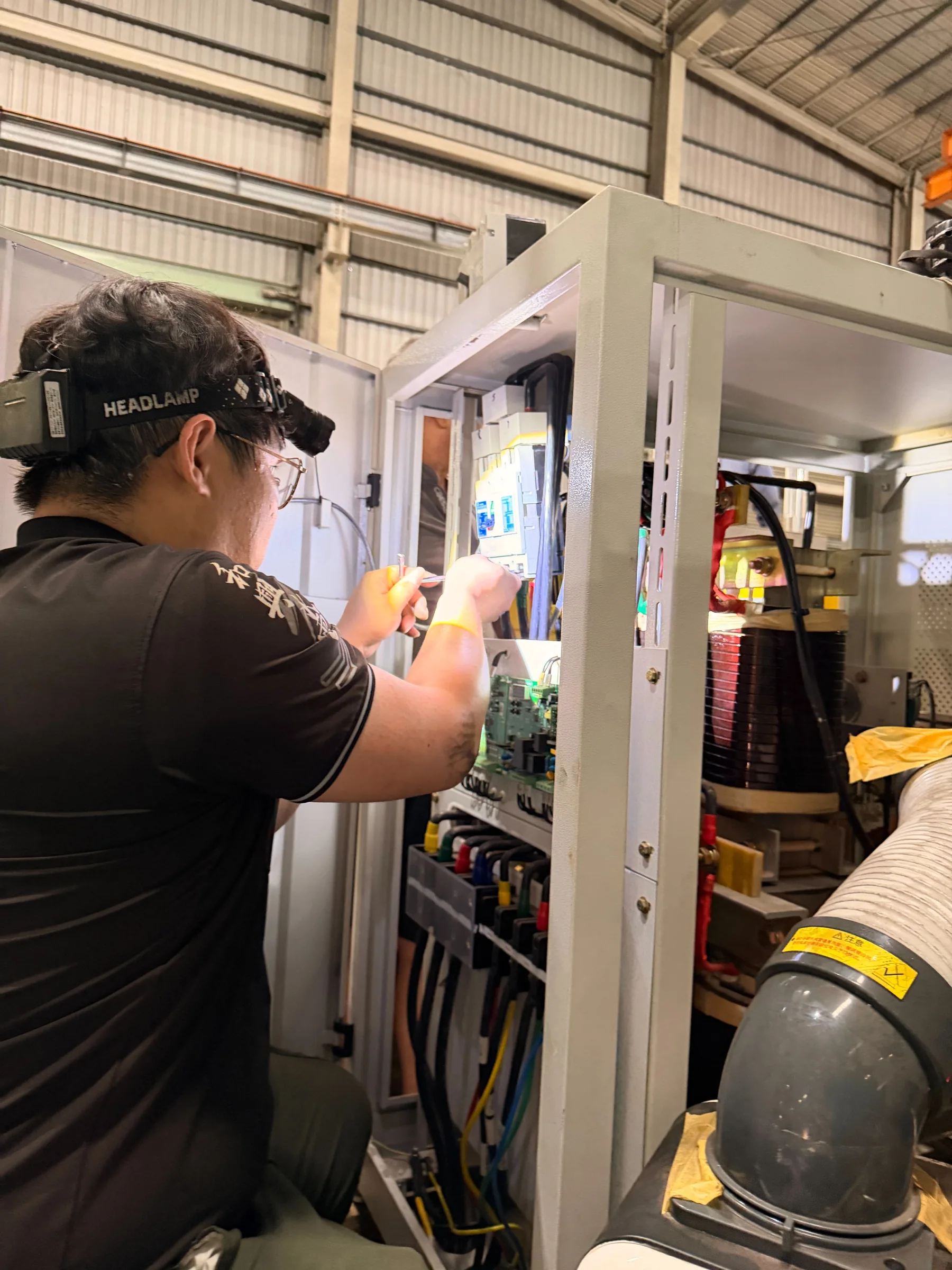 施工人員檢視配電控制箱內線路