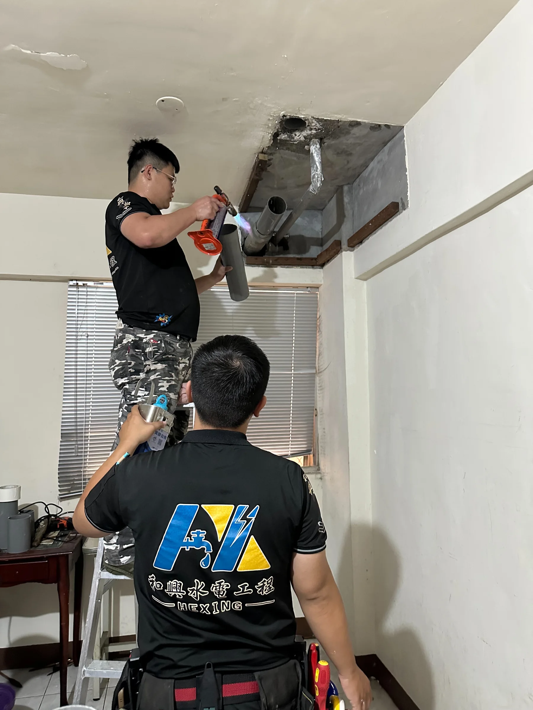 施工人員於天花板管道區域作業