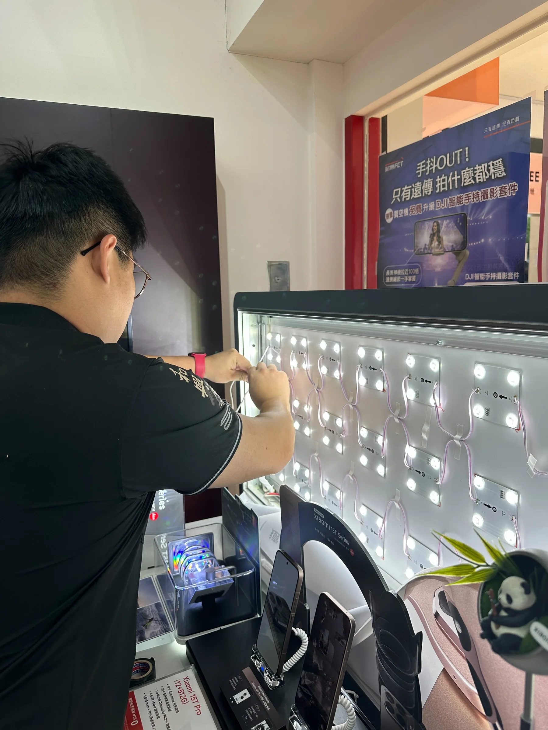 施工人員於展示設備內進行燈板作業